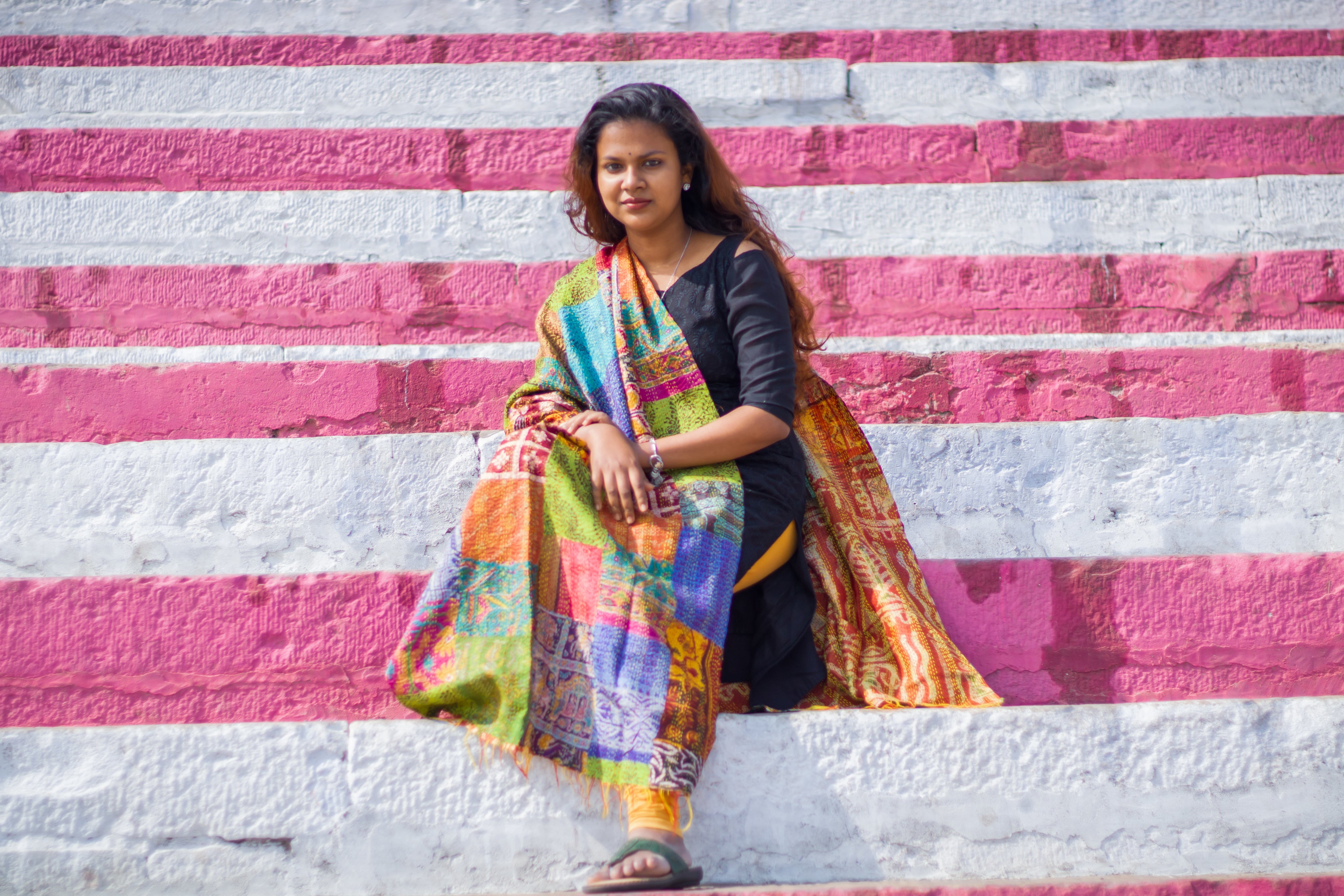 a-woman-sits-upon-a-pink-and-white-ledge.jpg
